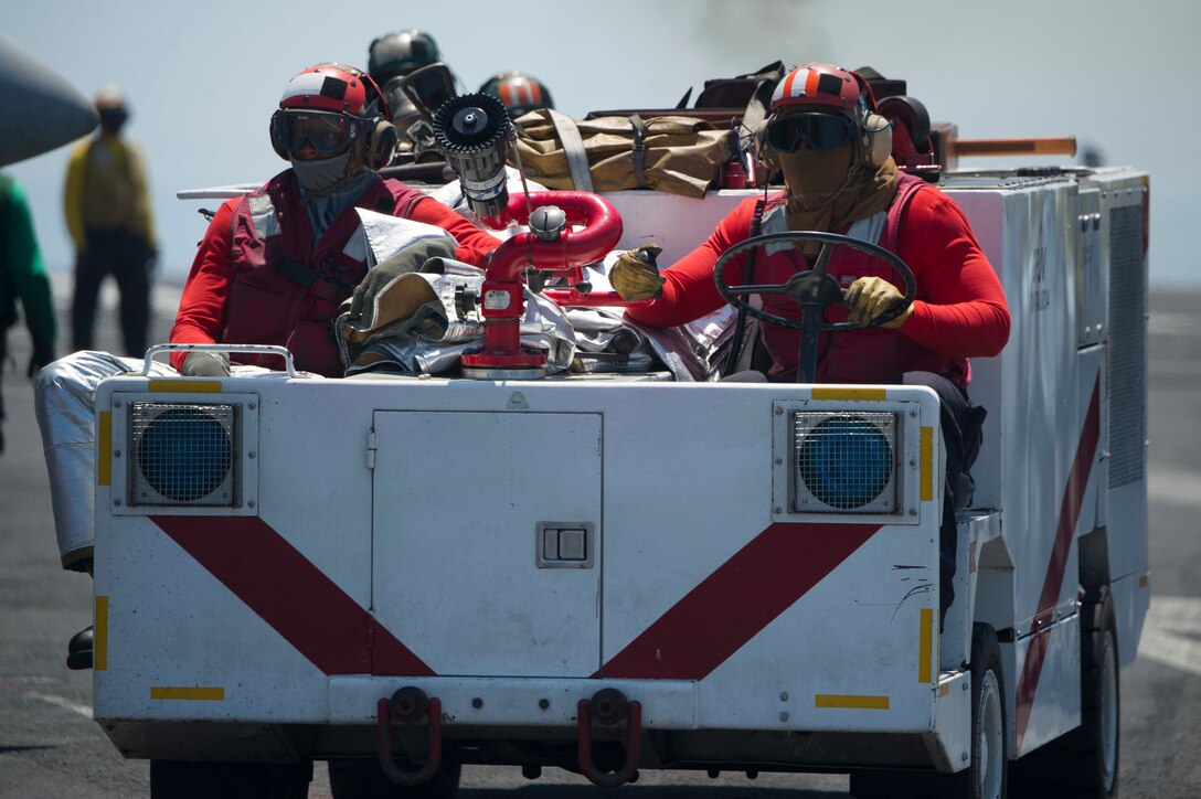 Sailors operate an aircraft firefighting vehicle on the flight deck.