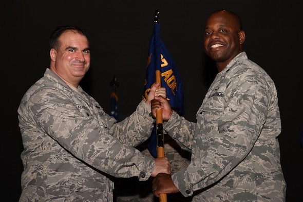 U.S. Air Force Lt. Col. Eddie Edwards receives the 607th Air Communications Squadron (ACOMS) guidon from Col. John Bartoli, 607th Air Operations Center commander, during a change of command ceremony at Osan Air Base, Republic of Korea, June 27, 2018. Edwards became the first commander of the 607th ACOMS, previously the 607th Support Squadron, re-designated under the new name during the ceremony. (U.S. Air Force photo by Senior Airman Kelsey Tucker)