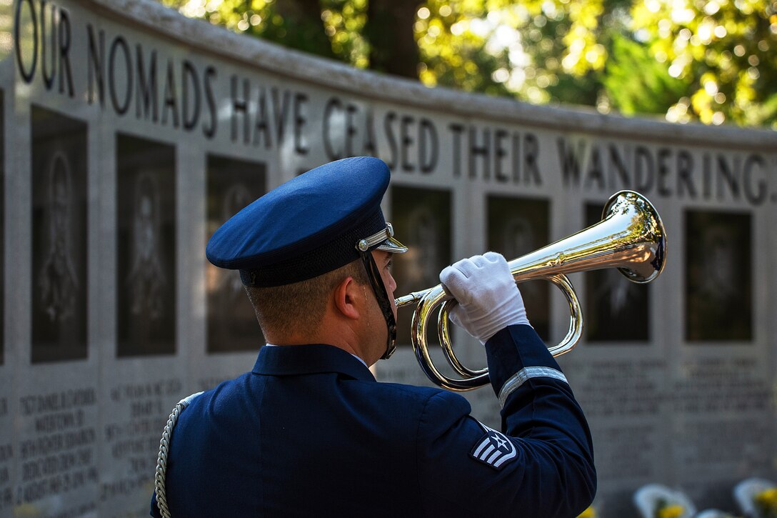 A service members plays Taps during a Khobar Towers Memorial Ceremony.