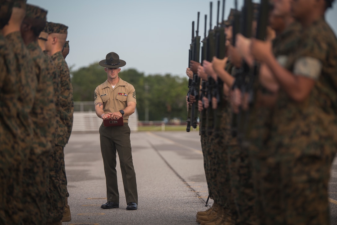 U.S. Marine Corps Drillmaster Staff Sgt. Ryan Guinty inspects recruits with Platoon 1057, Bravo Company, 1st Recruit Battalion during an initial drill evaluation June 25, 2018, on Parris Island, S.C. Drill instructors are evaluated on their appearance, sword control and cadence during the evaluation. Bravo Company is scheduled to graduate August 24, 2018. Parris Island has been the site of Marine Corps recruit training since Nov. 1, 1915. Today, approximately 19,000 recruits come to Parris Island annually for the chance to become United States Marines by enduring 13 weeks of rigorous, transformative training. Parris Island is home to entry-level enlisted training for approximately 49 percent of male recruits and 100 percent of female recruits in the Marine Corps.