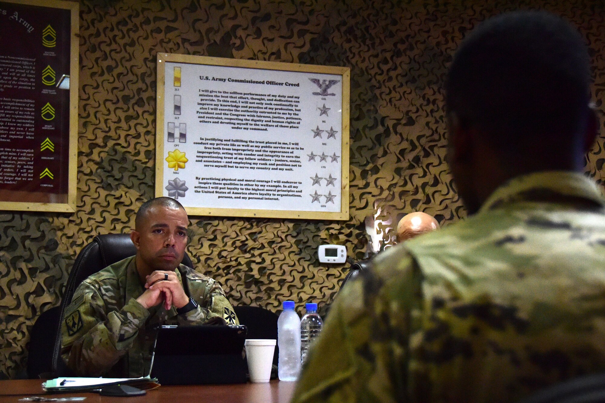 U.S. Army Command Sgt. Maj. Raymond Belk, 5-52 Air Defense Artillery (ADA) awaits an answer from Staff Sgt. Michael Bell, a section sergeant with Headquarters and Headquarters Battery, 5-52 ADA, during a leadership board, June 20, 2018, at Al Udeid Air Base, Qatar. The leadership board, a part of the Best Warrior Competition, challenges soldiers to answer basic soldiering tactic questions as well as answering the overall situational based questions that allows board members to rate the leadership capabilities of that competitor. (U.S. Air Force photo by Staff Sgt. Caitlin Conner)