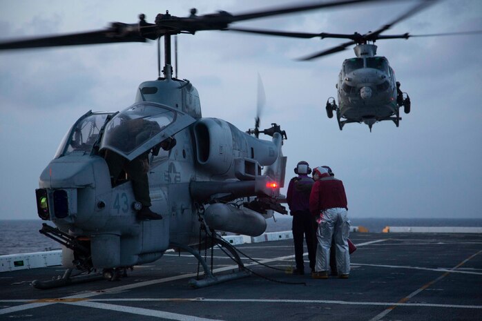 U.S. Navy flight crew with USS Arlington refuel a AH-1W “Super Cobra” attack helicopter with the 22nd Marine Expeditionary Unit as UH-1Y Huey “Venom” utility helicopter approaches the flight deck during Amphibious Squadron MEU Integration training in the Atlantic Ocean, June 13, 2018. PHIBRON-MEU Integration is a two-week training evolution that allows Sailors and Marines to train as a cohesive unit in preparation for their upcoming deployment.