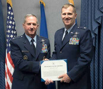 Lt. Col Daniel Finnegan receives the Koren Kolligian Trophy certificate from Air Force Chief of Staff Gen. David L. Goldfein in the Pentagon, Washington, D.C., June 25, 2018.