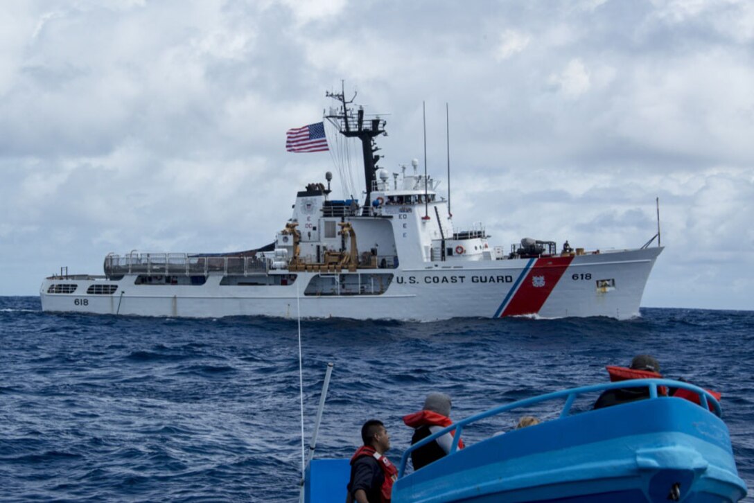 A Coast Guard cutter floats in the ocean as its crew performs a drug interdiction operation.