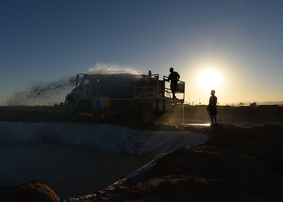 Airmen assigned to the 56th Civil Engineering Squadron fill an obstacle with water before the 56th Force Support Squadron’s 2018 Jump in the Mud 5K June 22, 2018, at Luke Air Force Base, Ariz.