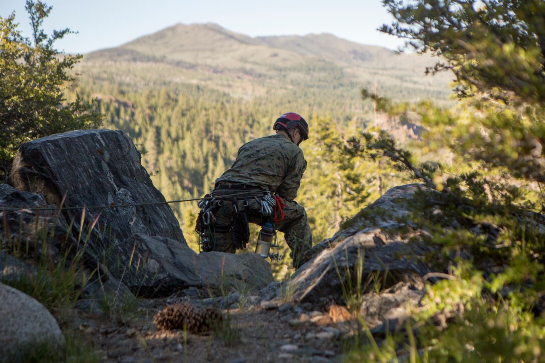 A reconnaissance Marine with 4th Reconnaissance Battalion, 4th Marine Division, watches to make sure a Marine safely rappels down a cliff side, during Mountain Exercise 3-18, at Mountain Warfare Training Center, Bridgeport, Calif., June 20, 2018.