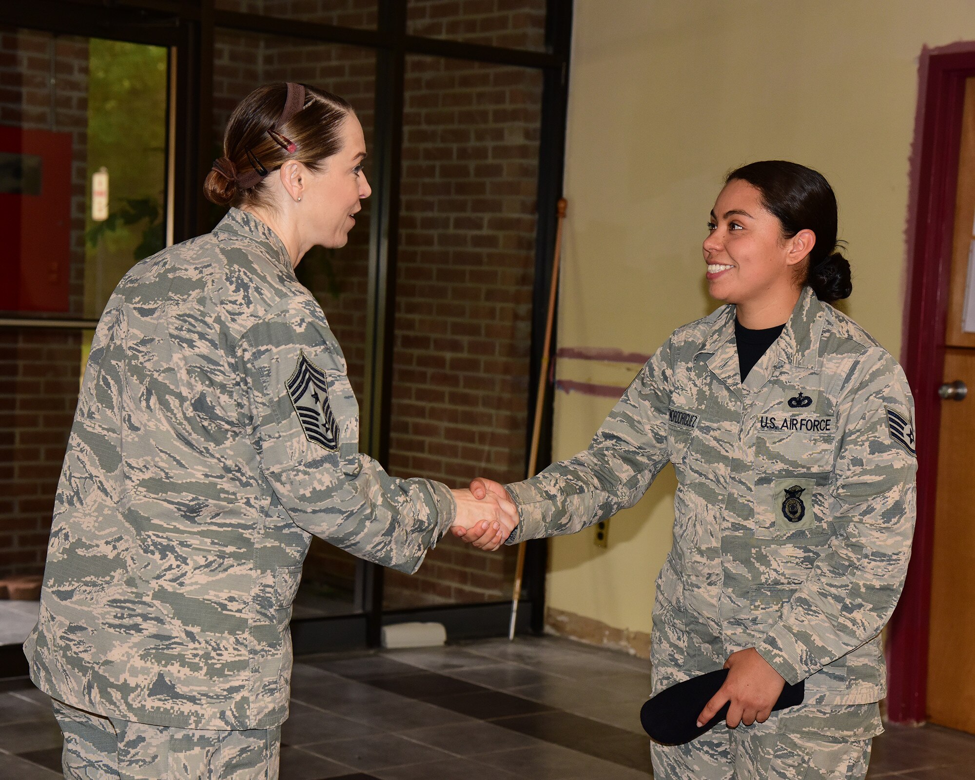 U.S. Air Force Chief Master Sgt. Juliet Gudgel, command chief of Air Education and Training Command, coins Staff Sgt. Mariel Constantino Rodriguez, 14th Security Forces Squadron noncommissioned officer in charge of standards and evaluation, at Columbus Air Force Base, Mississippi, June 22, 2018. Gudgel coined many top performing Team BLAZE Airmen for their hard work and dedication. (U.S. Air Force photo by Elizabeth Owens)