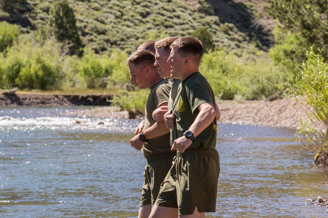 Marines with 2nd Battalion, 24th Marine Regiment, 23rd Marines, 4th Marine Division, cross an ice-cold stream, as part of a lesson on how to safely cross rushing water, during Mountain Exercise 3-18, at Mountain Warfare Training Center, Bridgeport, Calif., June 21, 2018.