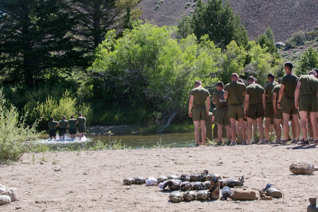 Marines with 2nd Battalion, 24th Marine Regiment, 23rd Marines, 4th Marine Division, wait to cross an ice-cold stream, as part of a lesson on how to safely cross rushing water, during Mountain Exercise 3-18, at Mountain Warfare Training Center, Bridgeport, Calif., June 21, 2018.