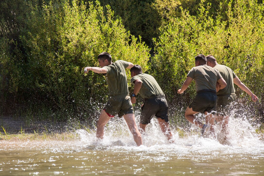 Marines with 2nd Battalion, 24th Marine Regiment, 23rd Marines, 4th Marine Division, rush to get out of an ice-cold stream, as part of a lesson on how to safely cross rushing water, during Mountain Exercise 3-18, at Mountain Warfare Training Center, Bridgeport, Calif., June 21, 2018.