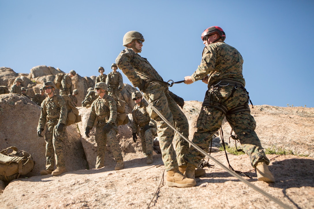 Sgt. Nicholas Fasano (right), an instructor with Marine Corps Mountain Warfare Training Center, tests the sturdiness of a knot before a Marine with 2nd Battalion, 24th Marine Regiment, 23rd Marines, 4th Marine Division, descends a cliffside, during Mountain Exercise 3-18, at MWTC, Bridgeport, Calif., June 22, 2018.