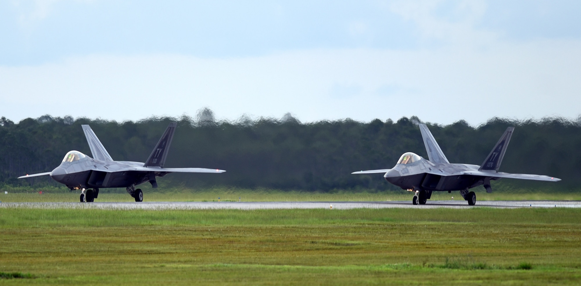 A pair of 95th Fighter Squadron F-22 Raptors prepare for takeoff at Tyndall Air Force Base, Fla., June 14, 2018. The aircraft were launched during a Phase II deployment exercise designed to simulate real-world tactics while testing the ability of maintenance teams and pilots to project unrivaled combat airpower at a moment’s notice. (U.S. Air Force photo by Airman 1st Class Isaiah J. Soliz)