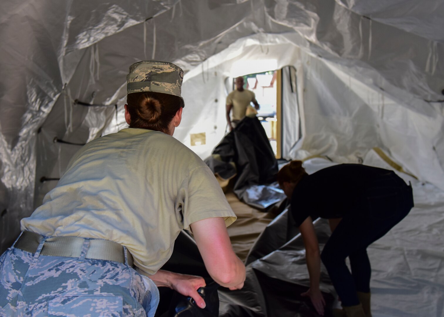 Expeditionary Medical Systems exercise volunteers fold tent equipment at Joint Base Langley-Eustis, Virginia, June 20, 2018. Airmen from the 633rd Civil Engineer Squadron, the 633rd Medical Support Squadron and the 633rd Dental Squadron volunteered to take part in the exercise. (U.S. Air Force photo by Airman 1st Class Monica Roybal)