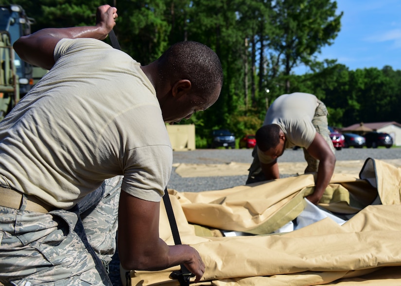 U.S. Air Force Staff Sgt. Matthew Bryles, 633rd Civil Engineer Squadron emergency management technician, and U.S. Air Force Senior Airman Bryce Carter, 633rd CES heating, ventilation and air conditioning technician, assemble tent components at Joint Base Langley-Eustis, Virginia, June 20, 2018. Exercise volunteers learned which new components worked interchangeably with both tents on display. (U.S. Air Force photo by Airman 1st Class Monica Roybal)