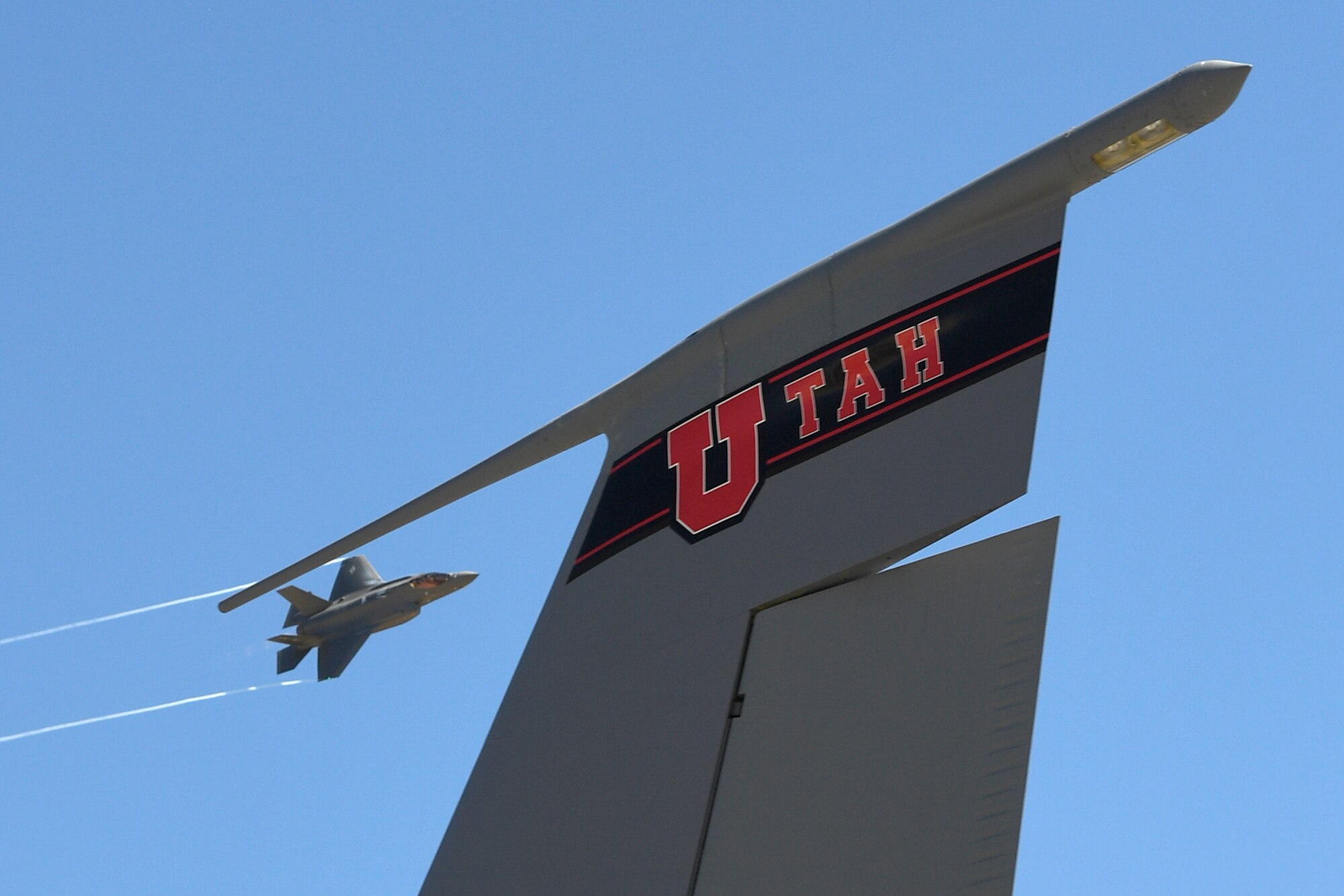 An F-35A Lightning II from the 388th Fighter Wing flies over the top of the vertical stabilizer on a Utah Air National Guard KC-135 static display during the Warriors Over the Wasatch Air and Space Show June 24, 2018, at Hill Air Force Base, Utah. The F-35 was part of a four-ship participating in an attack demonstration. (U.S. Air Force photo by Todd Cromar)