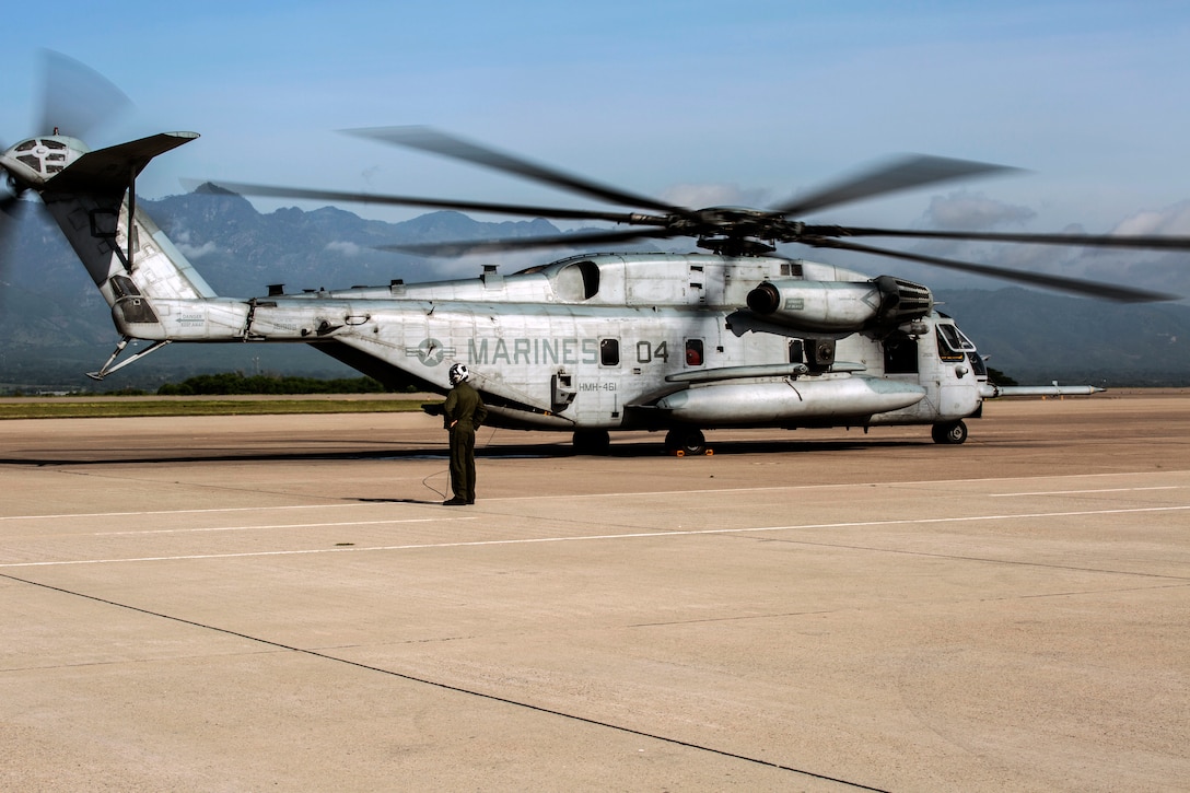 A Marine conducts and verifies preflight checks of a CH-53E Super Stallion helicopter on Soto Cano Air Base.