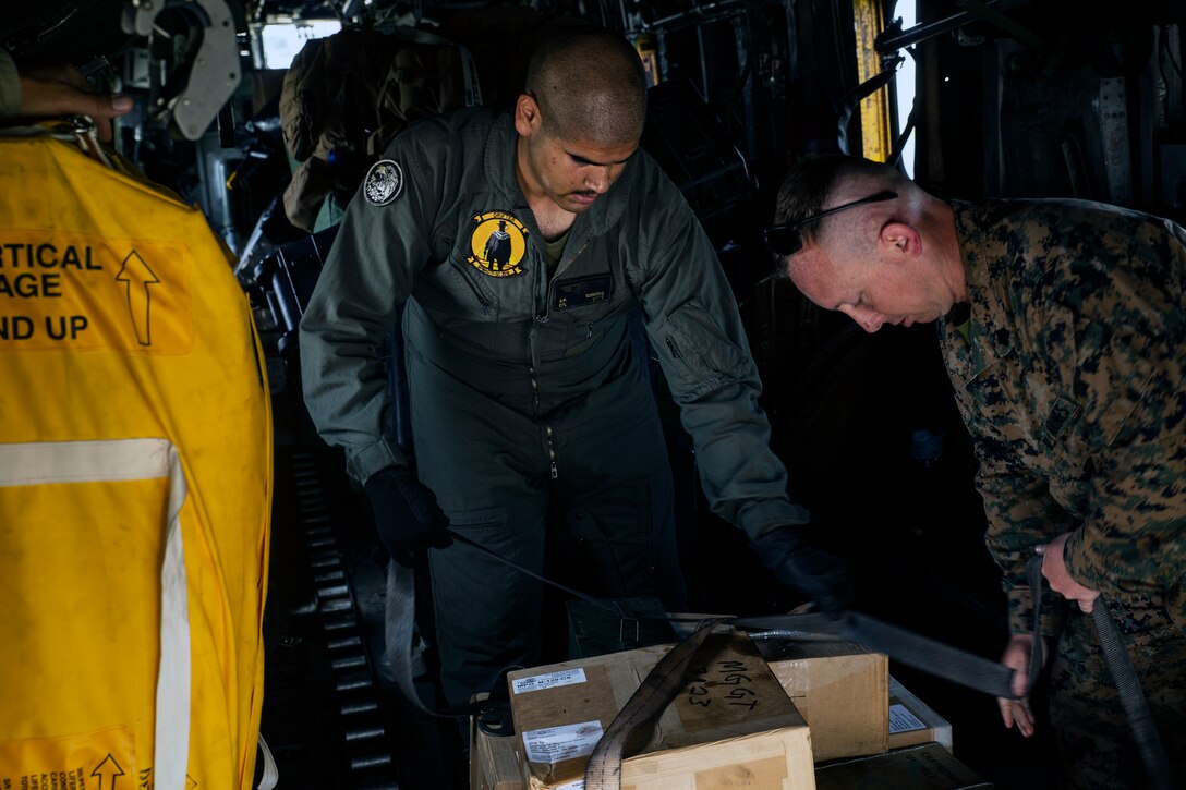 Marine Corps Cpl. Christian P. Cisneros, left, and Marine Corps Sgt. Trent T. Payne, deliver ammunition and equipment.