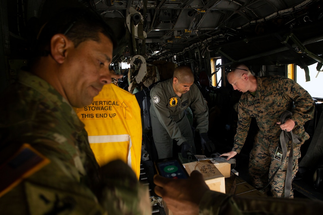Army soldiers unload ammunition and equipment from a CH-53E Super Stallion helicopter in Puerto Barrios, Guatemala.