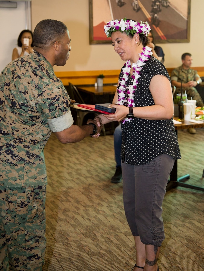 Lyndsay Kaulave, deputy command inspector, is congratulated by Col. Sakou Karega, base commander, after presenting her with a Civilian Meritorious Service Award in recognition of her outstanding work during her tenure aboard Marine Corps Logistics Barstow, June 26.