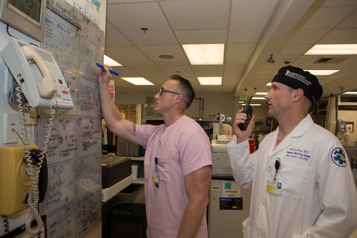 Col. Joseph DuBose, trauma surgeon and director of the Center for the Sustainment of Trauma and Readiness Skills (C-STARS) Baltimore, and Master Sgt. Shane Patterson, a respiratory therapist and superintendent of C-STARS Baltimore, receive a report on an incoming patient at the Trauma Resuscitation Unit (TRU) at the University of Maryland Medical Center, Baltimore, June 13, 2018. The U.S. Air Force’s C-STARS Baltimore program partners with the R Cowley Shock Trauma Center at the University of Maryland Medical Center to ensure medical Airmen train on the latest trauma care techniques. These techniques prepare medical Airmen to treat trauma patients in a deployed setting. (Courtesy photo)