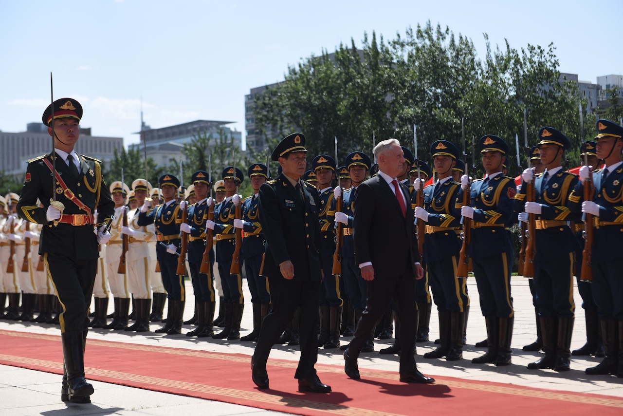 Chinese general and U.S. defense secretary pass troops in formation.