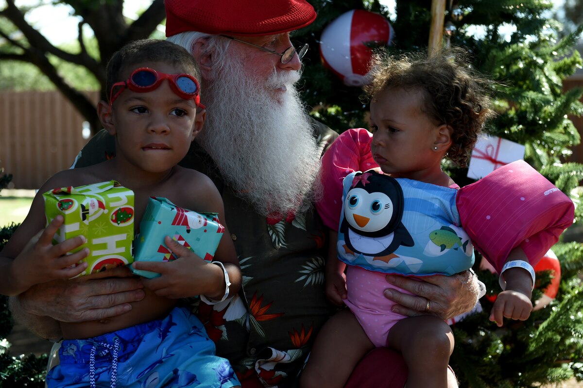Jett (left) and Nova (right) Smith, children of U.S. Air Force Tech Sgt. Smith, a military training leader assigned to the 97th Training Squadron, sit on Santa’s lap for the Hearts Apart Christmas event, June 22, 2018, at Altus Air Force Base, Okla.