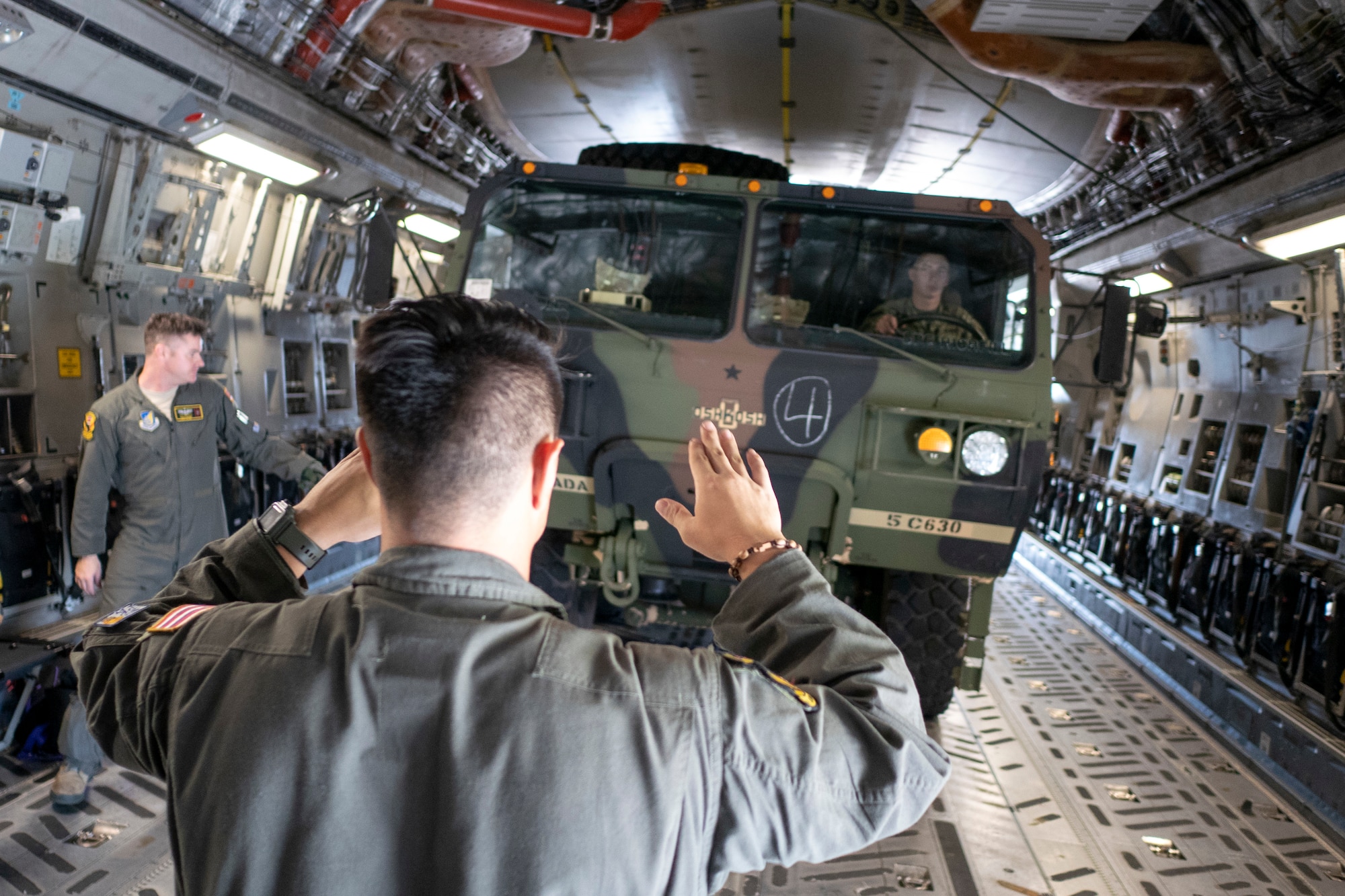 Staff Sgt. Josh Moracco, 204th Airlift Squadron loadmaster guides a heavy expanded mobility tactical truck onto a C-17 Globemaster III, operated by the Hawaii Air National Guard, during exercise Swift Response 18 on June 9, 2018, at Ramstein Air Base, Germany