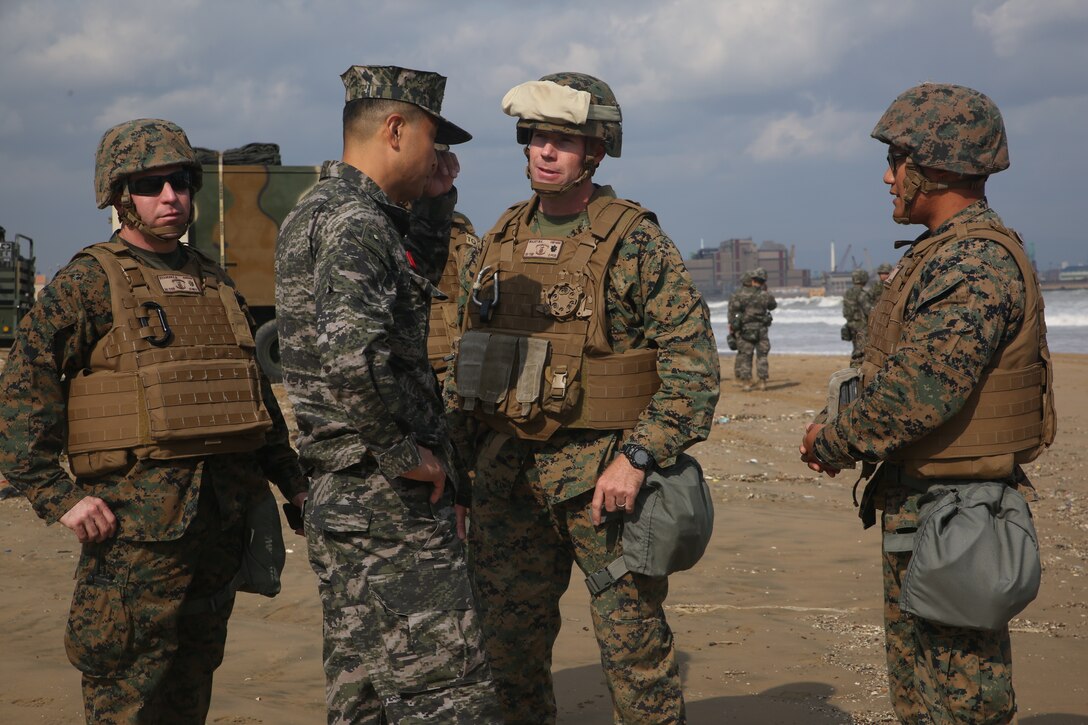 Republic of Korea Marine Lt. Col. Seung-Hoon Lee, commanding officer of the Landing Support Battalion, ROK Marine Logistics Group, center left, speaks with U.S. Marine Lt. Col. Matthew Mulvey, center right, commanding officer of 3d Transportation Support Battalion, Combat Logistics Regiment 3, during bilateral convoy operations Oct. 26, 2017 at Dogu Beach, Pohang, South Korea. U.S. Marines with 3d TSB, CLR-3, 3d MLG and ROK Marines with Landing Support Battalion, ROK MLG participated in the bilateral convoy as a part of CLR-3’s Mission Rehearsal Exercise during Exercise Winter Workhorse 17/Korean Marine Exchange Program 18.1. KMEP 18.1 familiarizes the American armed forces with the Korean Peninsula and builds upon an enduring alliance between the two militaries. (U.S. Marine Corps photo by Sgt. Tiffany Edwards)