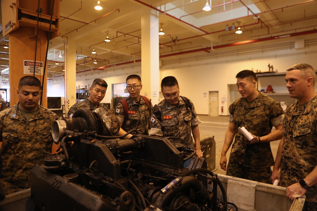 Official members of the Republic of Korea (ROK) Marine Logistics Group (MLG) examine equipment during their tour of the 3d Maintenance Battalion building aboard Camp Kinser, Okinawa, Japan, Nov. 1, 2017. U.S. Marine leadership explained how they use their equipment in order to conduct operations in garrison.  3d MLG is committed to developing enduring relationships with its ROK MLG counterparts in order to increase its interoperability and become a more proficient logistics partner. (U.S. Marine Corps photo by Sgt. Kathy Nunez)