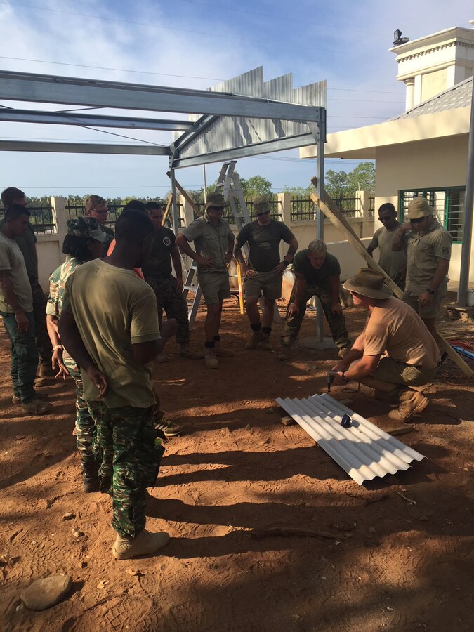 Australian Defense Force Pvt. Nunni and U.S. Marines with 9th Engineer Support Battalion put up metal sheathing for a brand new car port during Harii Hamutuk 17 at Metinaro Military Base, Timor-Leste, Oct. 22, 2017.  Harii Humutuk, Tetun for “build together,” lays the foundation for strong military-to-military relationships between Timor-Leste, Australia, Japan and U.S. Forces. (U.S. Marine Corps Courtesy Photo)