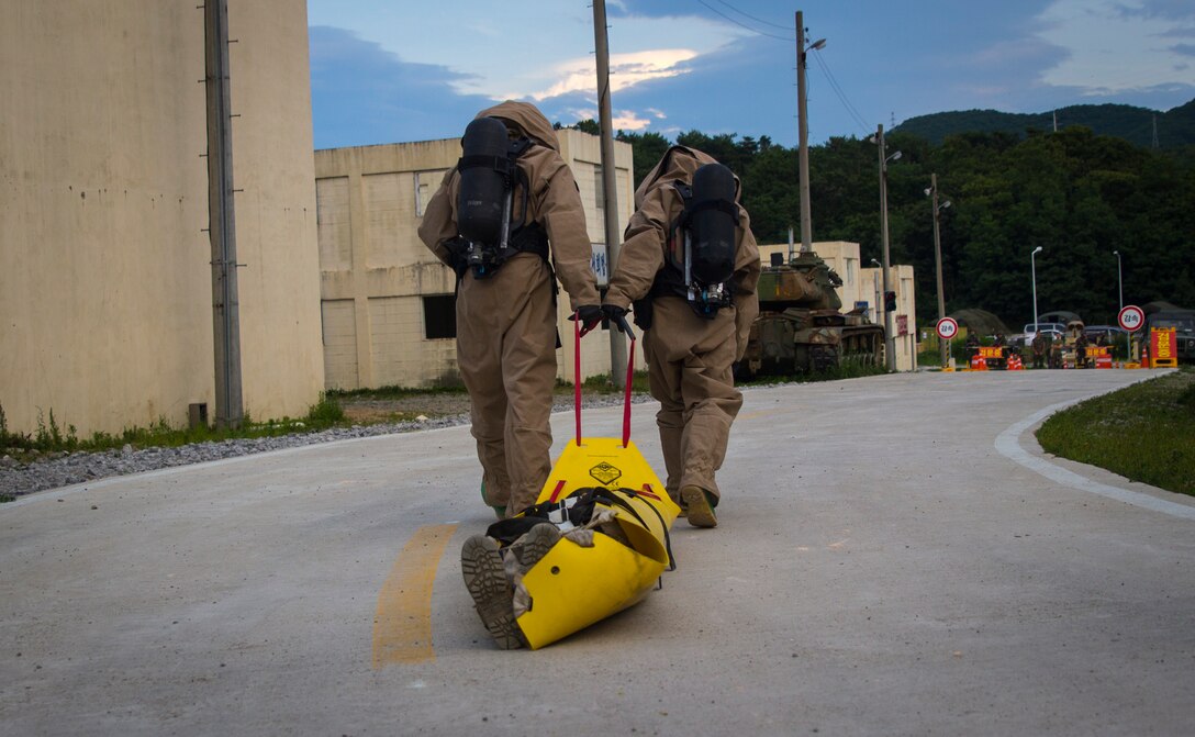 U.S. Marine Corps Lance Cpl. Ivan Franck (Left) and Lance Cpl. Andres Gomez (Right), both chemical, biological, radiological and nuclear defense specialist, drag a simulated casualty toward the decontamination center at Pohang, South Korea, June 30, 2017 during the Korean Marine Exchange Program 17-7. The scenario provided U.S. and ROK Marines with an opportunity to practice the skills necessary to detect and identify CBRN threats together. KMEP is a continuous bilateral training exercise that promotes stability on the Korean Peninsula while enhancing the ROK and U.S. alliance. Franck is from Brooklyn, New York, and Gomez is a Los Angeles native. Both are with 3rd Marine Logistics Group Headquarters Regiment, 3rd MLG, III Marine Expeditionary Force. (U.S. Marine Corps photo by Lance Cpl. Andy Martinez)