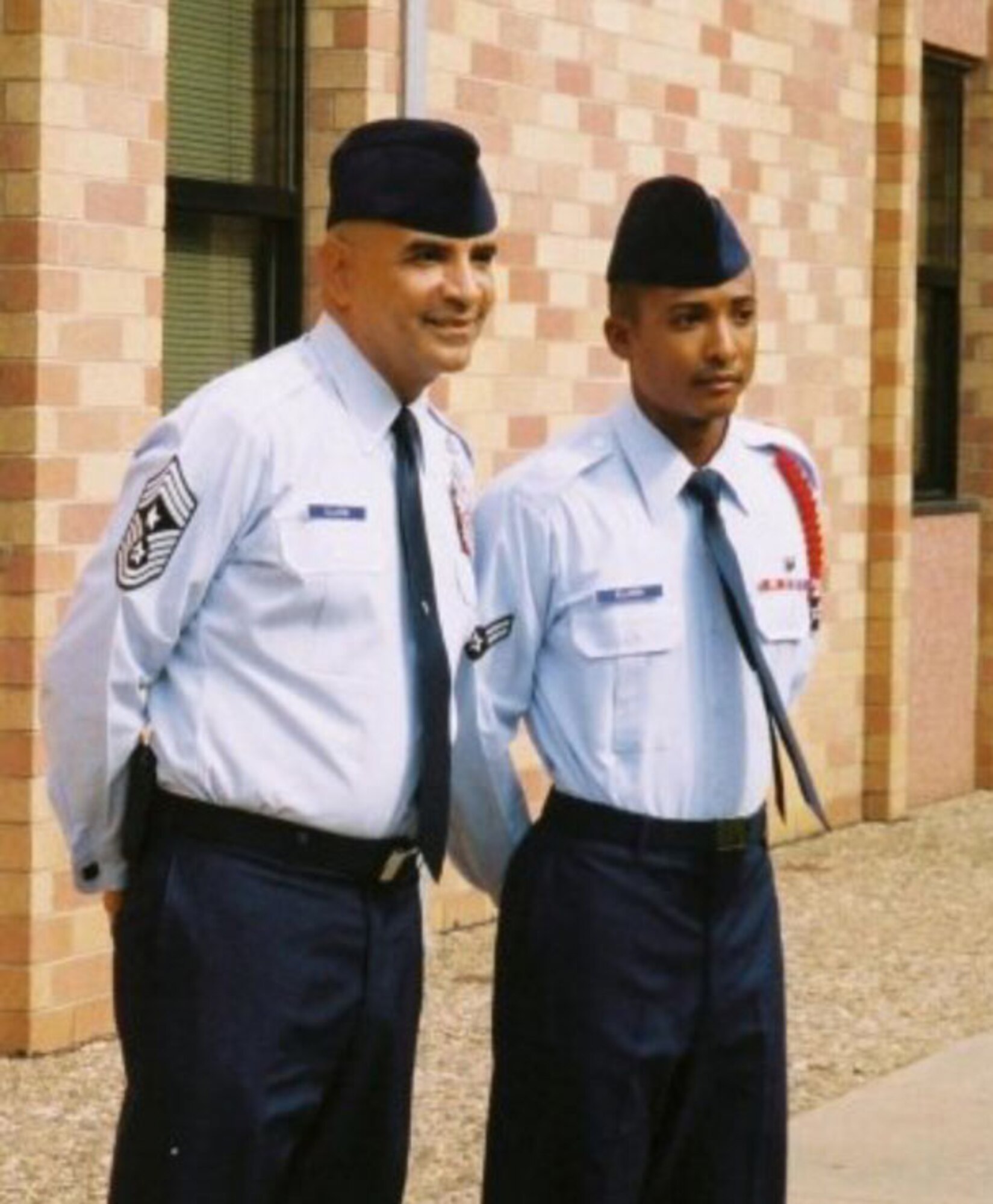 Then, Amn 1st Class, now, 1st Lt. Kenneth Ellison stands next to his uncle, Chief Master Rodney Ellison during his technical school graduation in 2004. Lieutenant Ellison graduated from Commissioned Officer Training June 22 at Maxwell Air Force Base, Ala and is continuing his family's tradition of service, which dates back to September 1947, when his grandfather started Air Force Basic Training.