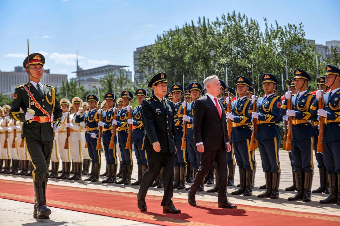 Defense Secretary James N. Mattis and his Chinese counterpart walk on a red carpet past a line of troops outside.