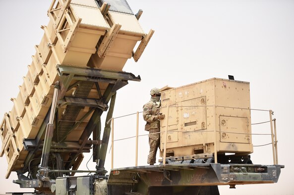 U.S. Army soldier stands on top of a large truck