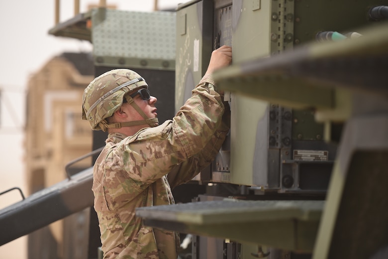 U.S. Army Soldier touches a large truck