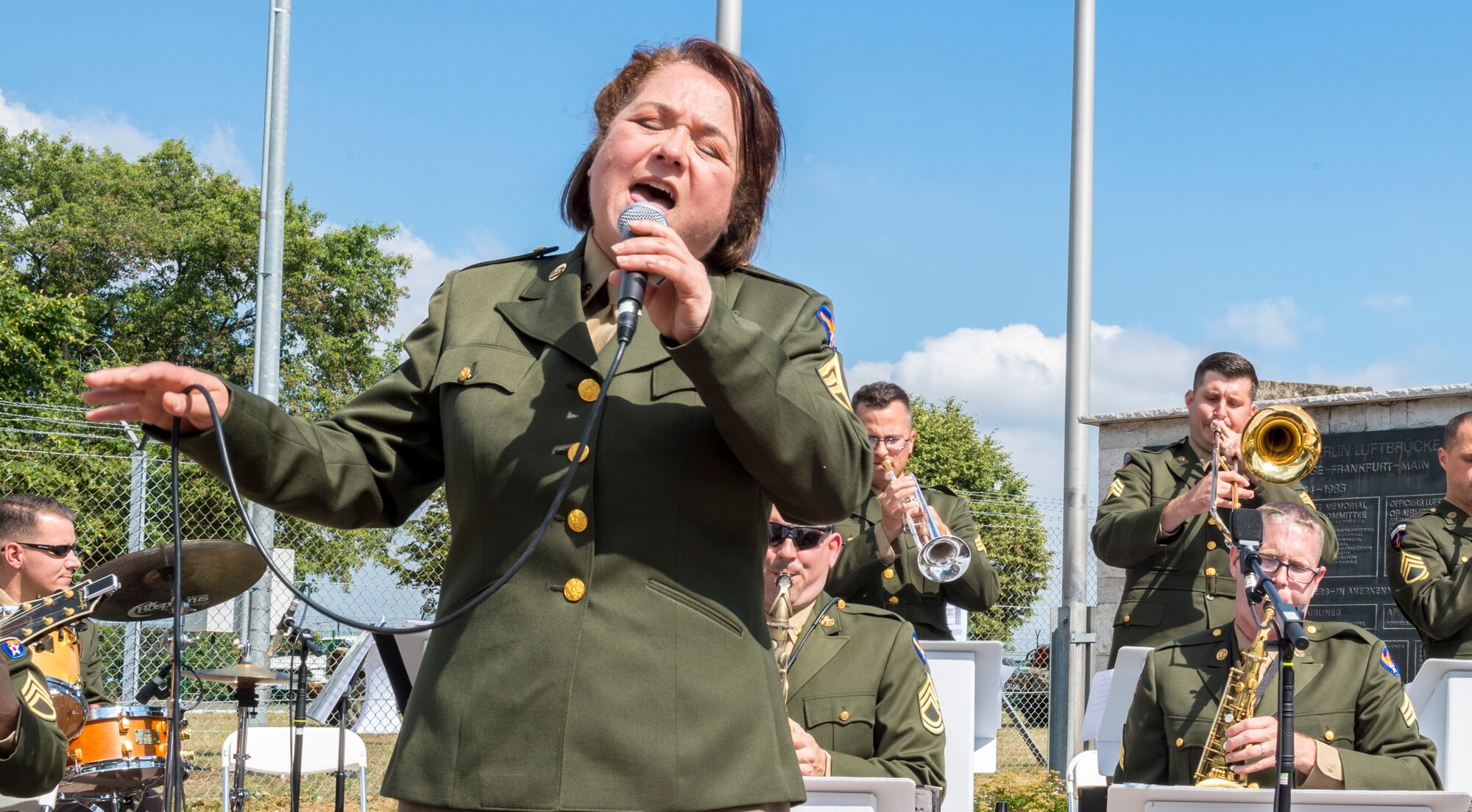 Master Sgt. Michele Harris and members of the United States Air Forces in Europe jazz band performing during the ceremony for the 70th anniversary of the Berlin Airlift, June 26, 2018, in Frankfurt, Germany. The Berlin Airlift memorial ceremony honored the 70th Anniversary of the beginning of the Berlin Airlift. The event also honored the 101 lives lost from the participating countries. (U.S. Air Force photo by Senior Airman Nick Emerick)