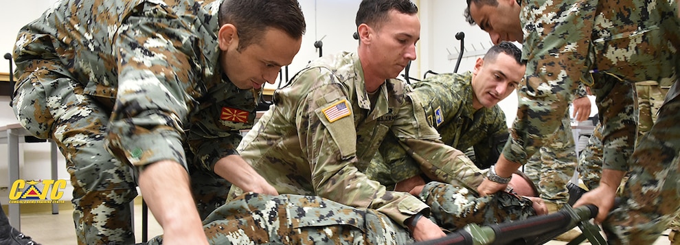 U.S. Army Spc. Gunner Boone, center, assigned to 1st Squadron, 91st Cavalry Regiment, 173rd Airborne Brigade teaches the usage of a folding litter to Macedonian soldiers during a Combined Arms Training Center (CATC) Combat Lifesaver course on Rose Barracks, Vilseck, Germany, June 13, 2018. This course teaches immediate, far-forward medical care on a widely dispersed battlefield while awaiting further medical treatment and evacuation. (U.S. Army photo by Gertrud Zach)