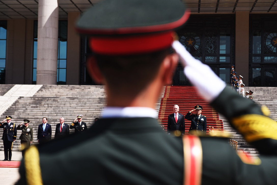 A soldier salutes as Defense Secretary Mattis and China’s Minister of National Defense Wei Fenghe perform a pass and review.