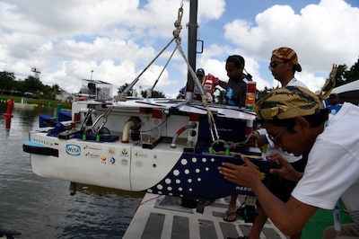 Students launch an autonomous boat during a competition.