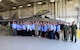 Civic leaders pose for photo in front of F-22 Raptor.