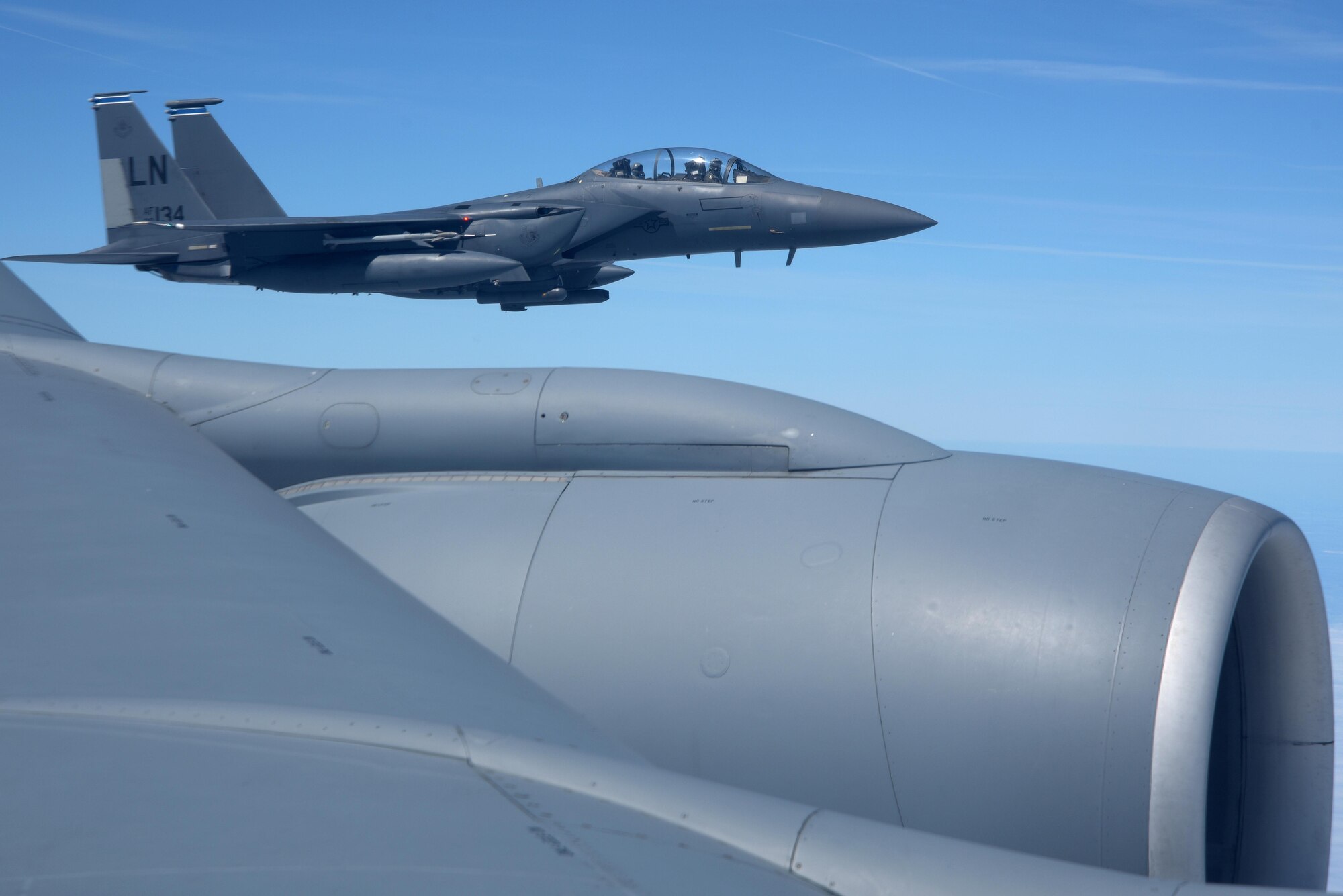 A U.S. Air Force F-15E Strike Eagle from the 492nd Fighter Squadron assigned to RAF Lakenheath flies alongside a U.S. Air Force KC-135 Stratotanker from over England, June 26, 2018. The honorary commanders were able to witnessed air refueling between the Bloody Hundredth and RAF Lakenheath. (U.S. Air Force photo by Airman 1st Class Benjamin Cooper)