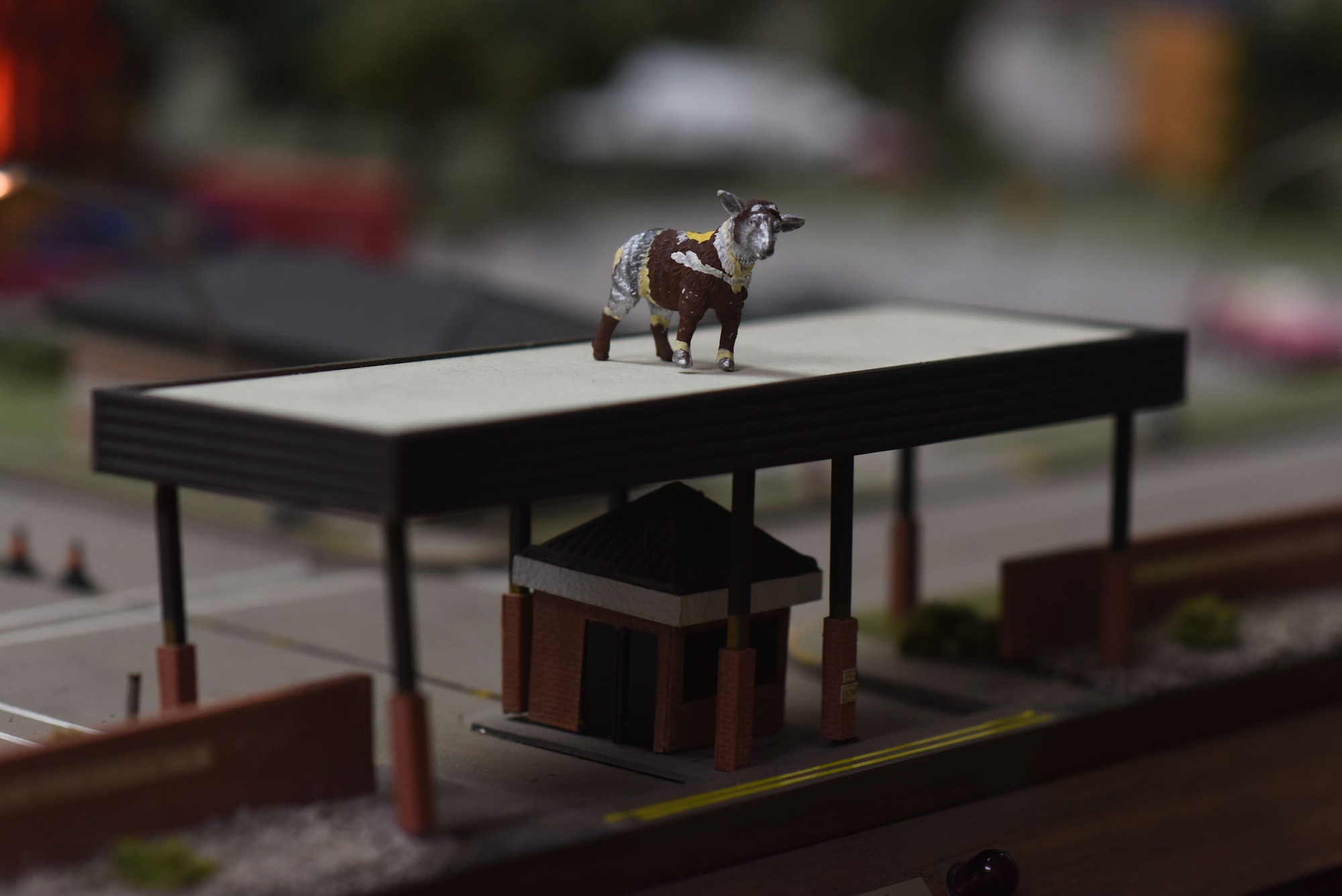 A miniature of Lt. Col. Ewe-Little, the sheep statue outside of Goodfellow Air Force Base’s gates, stands watch over the Norma Brown Air Force Base model in the Louis F. Garland Department of Defense Fire Academy on Goodfellow Air Force Base, Texas, June 21, 2018. The sheep are a tie to the early history of San Angelo as the wool and sheep capital of the world. (U.S. Air Force photo by Airman 1st Class Seraiah Hines/Released)