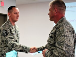 Master Sgt. Jason Wagner is coined by 340th FTG Commander, Col. Allen Duckworth during the 433rd TRS’ June unit training assembly for exceptional performance. (Courtesy Air Force photo)