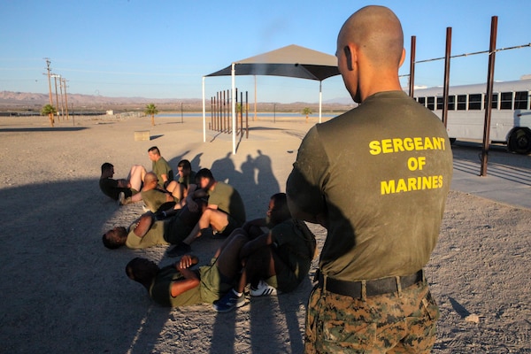 Sgt. Riordan T. Anunciacion, an intelligence specialist with Headquarters Company, 23rd Marine Regiment, 4th Marine Division, based in San Bruno, California, monitors Marines performing crunches during a physical fitness test at Integrated Training Exercise 4-18 at Marine Corps Air Ground Combat Center Twentynine Palms, California, on June 24, 2018. Monitoring PFTs is one of many responsibilities Anunciacion has taken on that led him to win the 23rd Marines Noncommissioned Officer of the Quarter award. (United States Marine Corps photo by Cpl. Alexis B. Rocha/released)