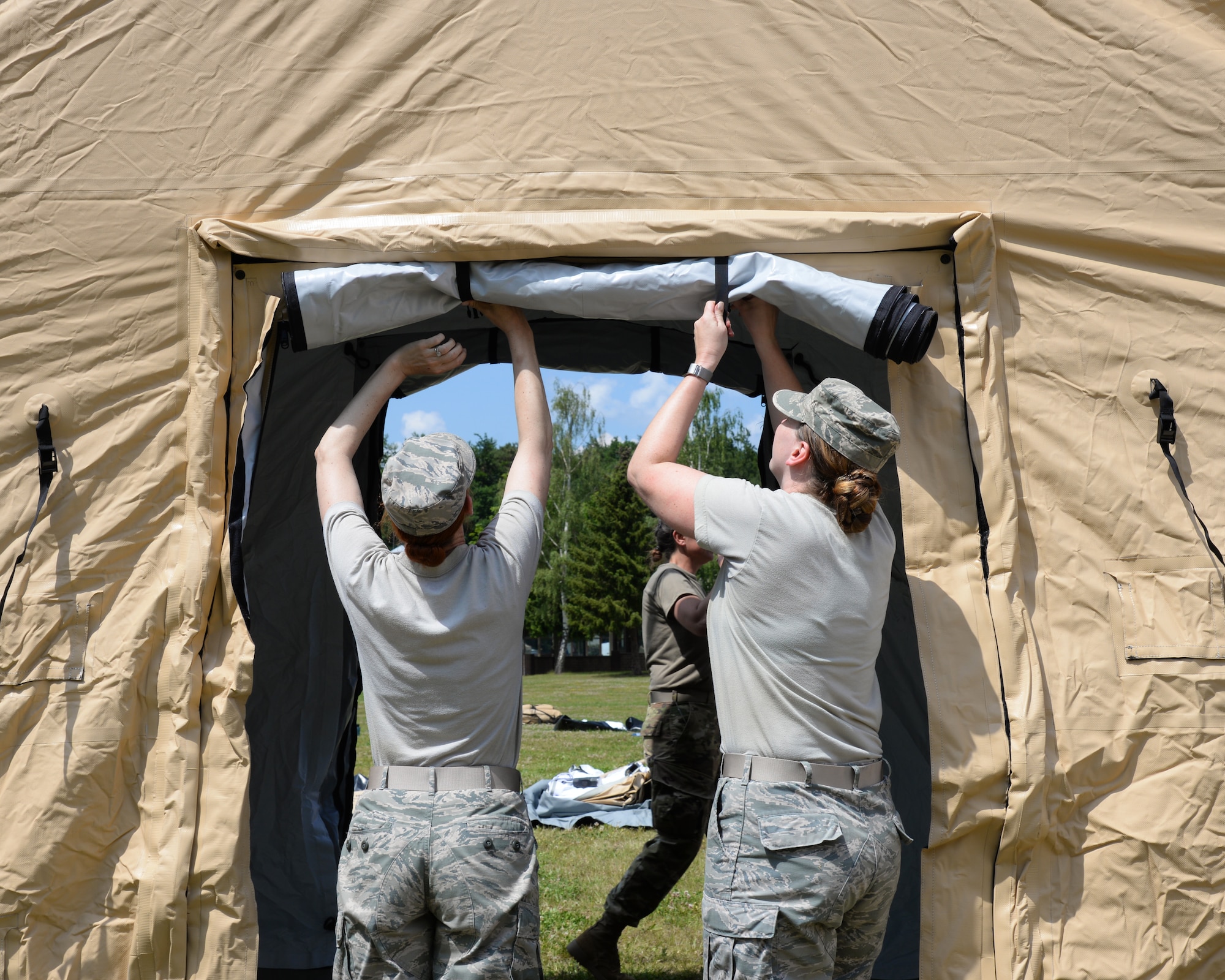 Airmen from the 86th Medical Group and the 86th Logistics Squadron set up an Expeditionary Medical Support System modular field hospital during en route patient staging training during Exercise Maroon Surge on Ramstein Air Base, Germany, June 4, 2018. The primary EMEDS missions are to: provide forward stabilization and resuscitative care; deliver primary care, dental services, and force health protection; and prepare casualties to evacuate to the next level of care. (U.S. Air Force photo by Airman 1st Class Ariel Leighty)