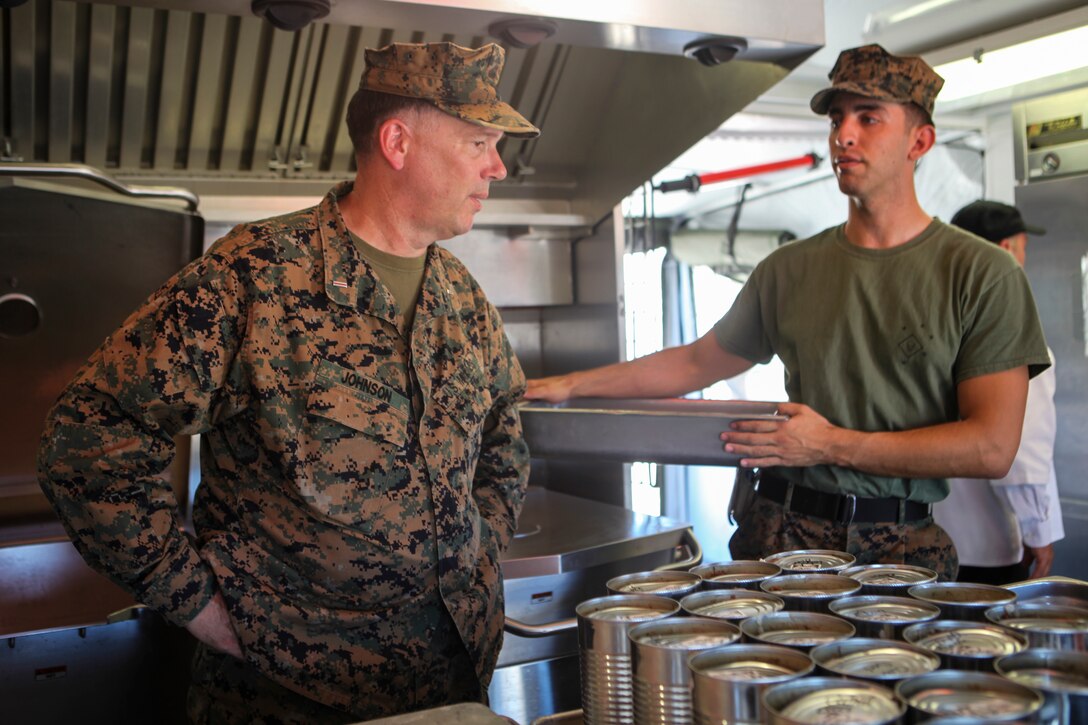 Cpl. Michael T. Moss, a food service specialist with Marine Wing Support Squadron 473, Marine Aircraft Group 41, 4th Marine Aircraft Wing, speaks with CWO5 Russell Johnson, a food service officer with Marine Forces Reserve and a judge of the Major General W. P. T. Hill Memorial Awards competition for Food Service Excellence, during Integrated Training Exercise 4-18 at Marine Corps Air Ground Combat Center Twentynine Palms, California, on June 22, 2018. The competitive spirit fostered by the Major General W.P.T. Hill awards program contributes to improved food service excellence and increased quality of life for our Marines and Sailors. (United States Marine Corps photo by Cpl. Alexis B. Rocha/released)