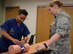 Tech. Sgt. Shanae Gallashaw, 99th Inpatient Operations Squadron critical care technician, and 1st Lt. Megan Huntley, 99th Medical Squadron pediatric nurse, practice proper first aid techniques using a tourniquet during the Stop the Bleed course at Mike O' Callaghan Military Medical Center on Nellis Air Force Base, Nevada, June 22, 2018. The University Medical Center of Southern Nevada and Nellis Air Force Base have partnered to teach approximately 40 Stop the Bleed instructors to educate members of the community on crisis care. (U.S. Air Force photo by Airman Bailee A. Darbasie)