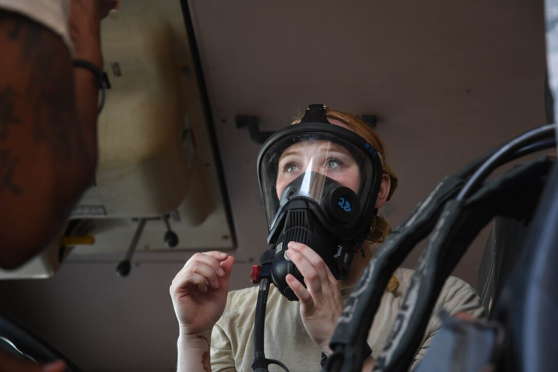 Senior Airman Rachel Johnson, 380th Civil Engineering Squadron emergency manager, learns how to properly put on an oxygen tank mask during her ‘Firefighter for a Day’ training at Al Dhafra Air Base, June 25. Johnson was the first to volunteer and participate in the program created by the 380th Civil Engineering Squadron Fire Department. (U.S. Air Force photo by Staff Sgt. Erica Rodriguez)