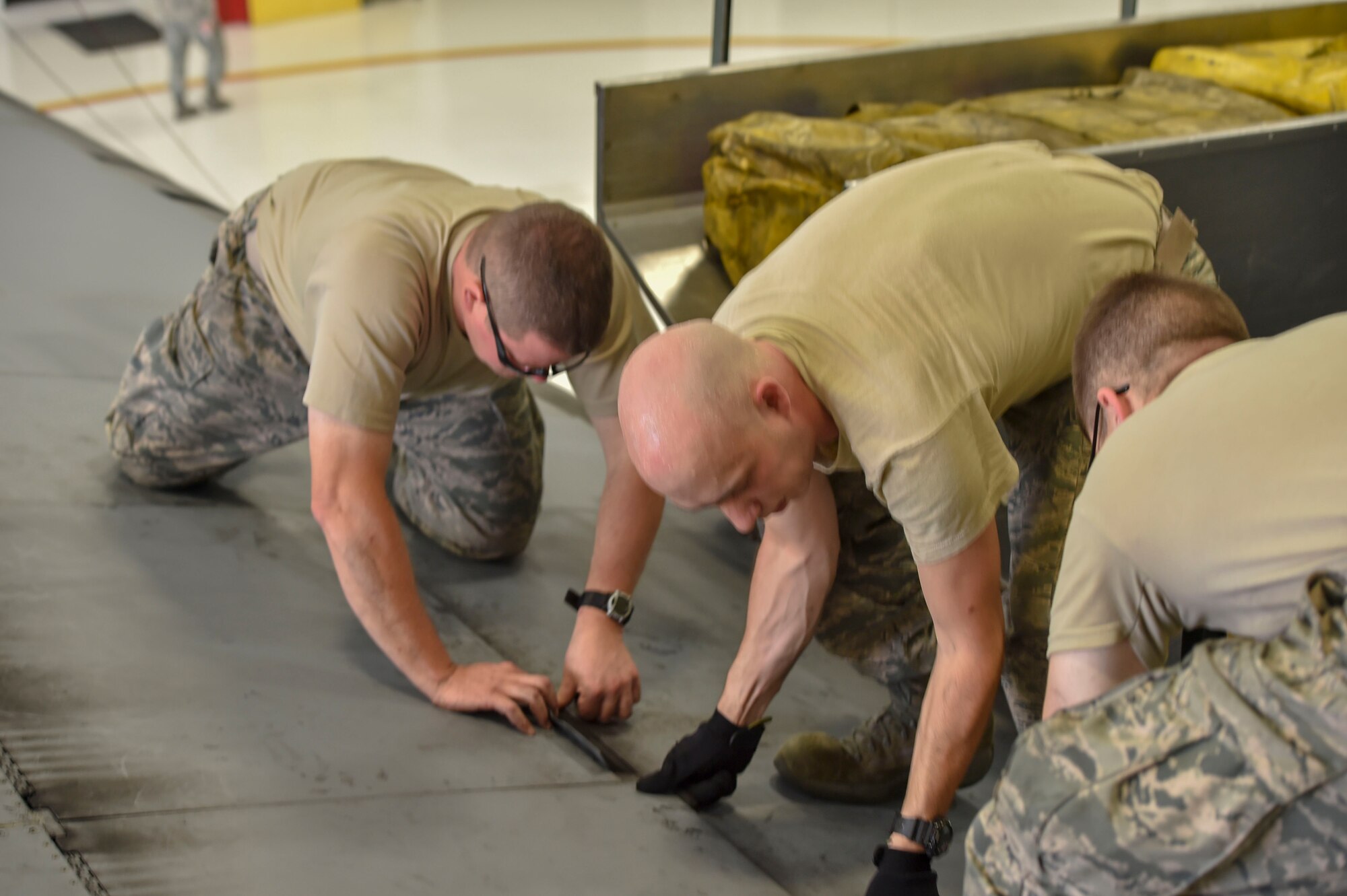 Airman Dustin Bruce, Senior Airman William Hizer and Master Sgt. Dan Scott, all aircraft maintenance technicians with the 910th Aircraft Maintenance Squadron, close a life raft compartment on the wing of a C-130H Hercules aircraft after removing the rafts here, June 13, 2018.