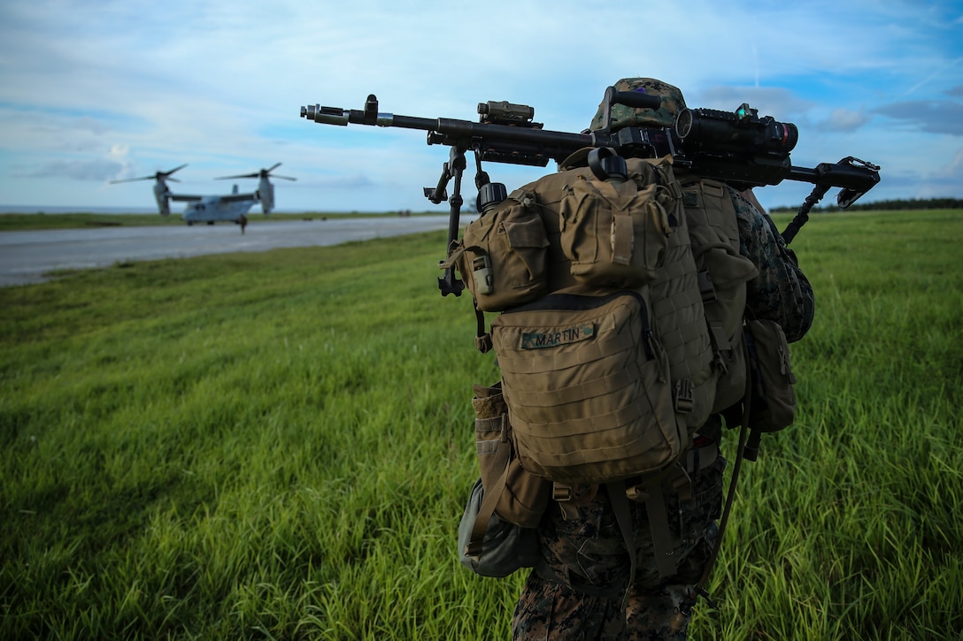 Pfc. Braeden Martin, a machine gunner with Fox Company, Battalion Landing Team, 2nd Battalion, 5th Marines, and a native of Moore, Oklahoma, moves toward a waiting MV-22B Osprey tiltrotor aircraft after completing a simulated helicopter raid as part of the 31st Marine Expeditionary Unit’s MEU Exercise at Ie Shima Training Facility, Okinawa, Japan, June 25, 2018. MEUEX is the first in a series of pre-deployment training events that prepare the 31st Marine Expeditionary Unit to deploy at a moment’s notice. The 31st MEU, the Marine Corps' only continuously forward-deployed MEU, provides a flexible force ready to perform a wide-range of military operations.
